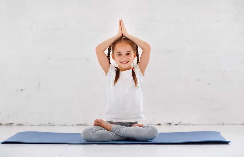 ‘Niños autónomos, adultos inteligentes’ escrito por Olimpia Tarda - Niña haciendo yoga en un aula Montessori - International Montessori School en Sotogrande, Cádiz