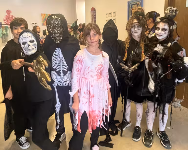 Grupo de alumnos del IMS Sotogrande con disfraces de Halloween — calaveras, esqueletos y brujas — en el colegio
