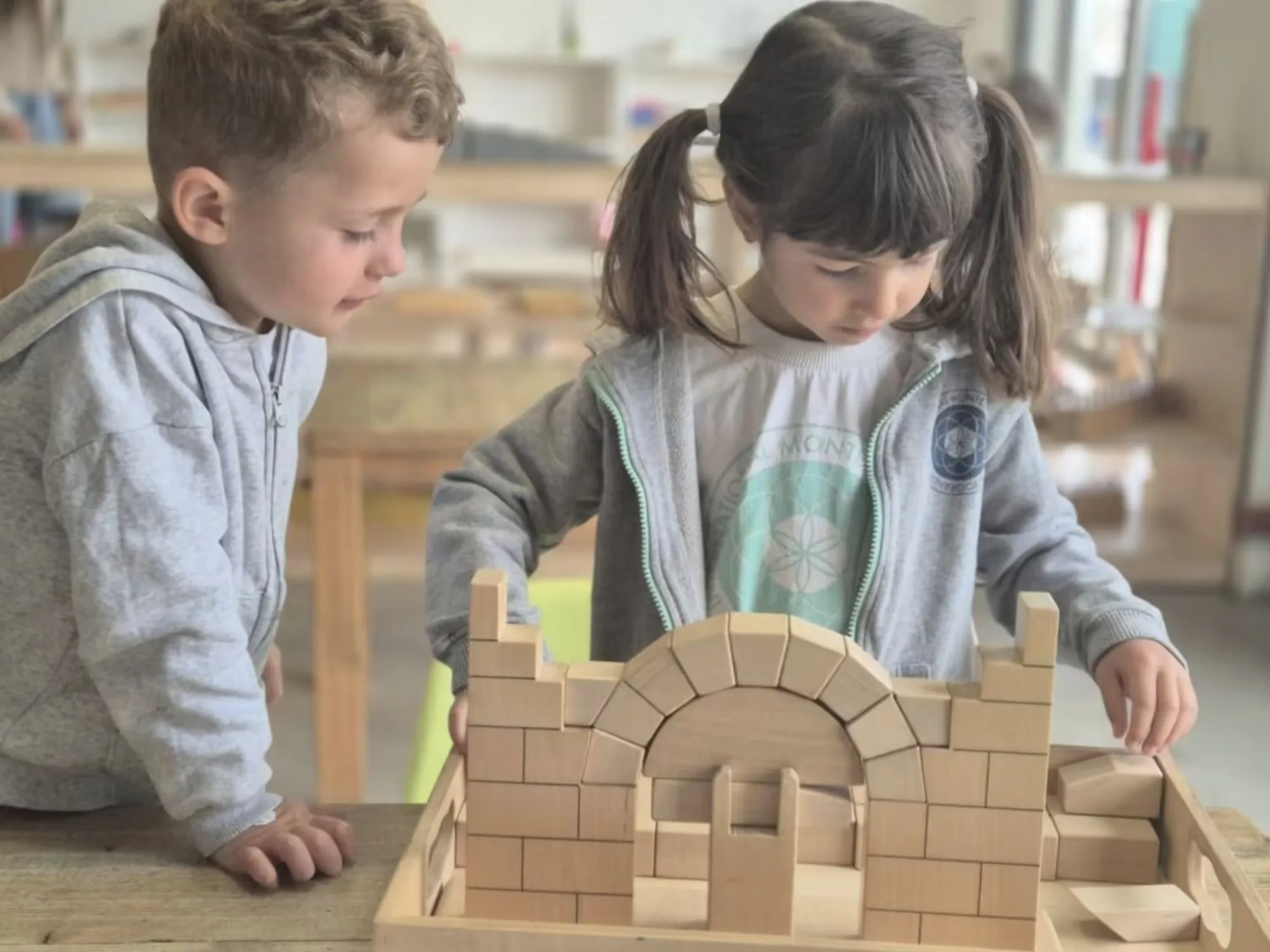Niño construyendo una torre con bloques Montessori y aprendiendo del error cuando se cae