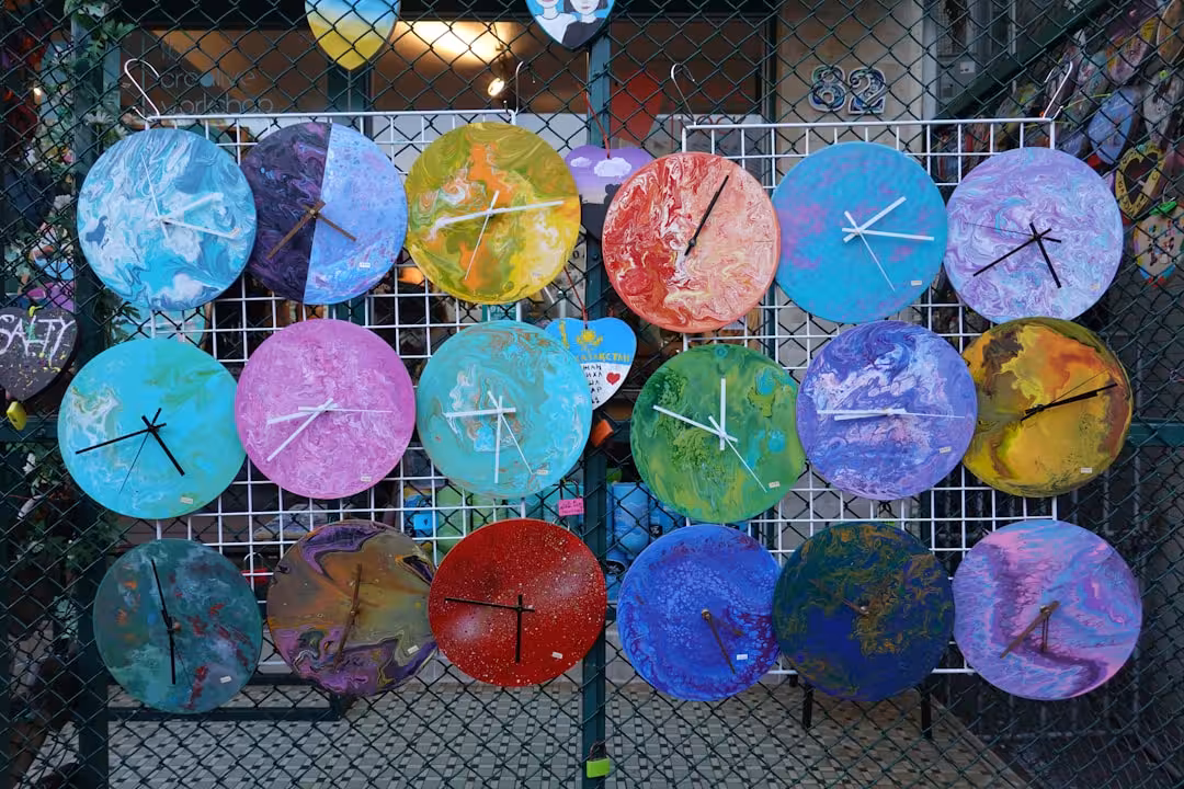 a bunch of colorful umbrellas hanging on a fence