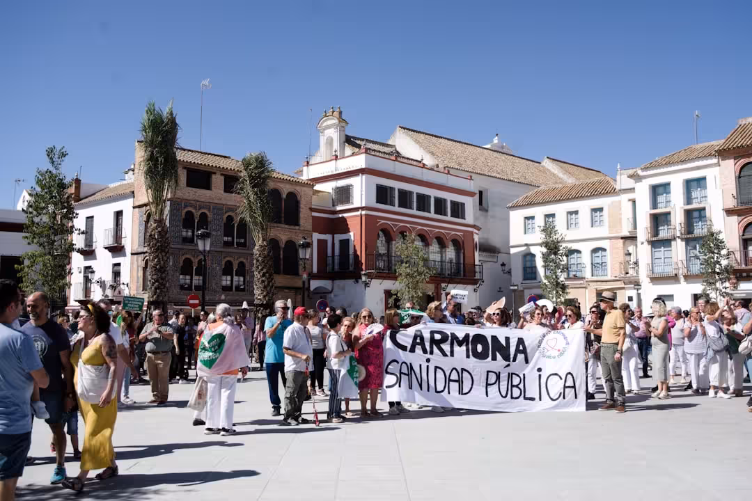 A group of people holding a sign in front of a building