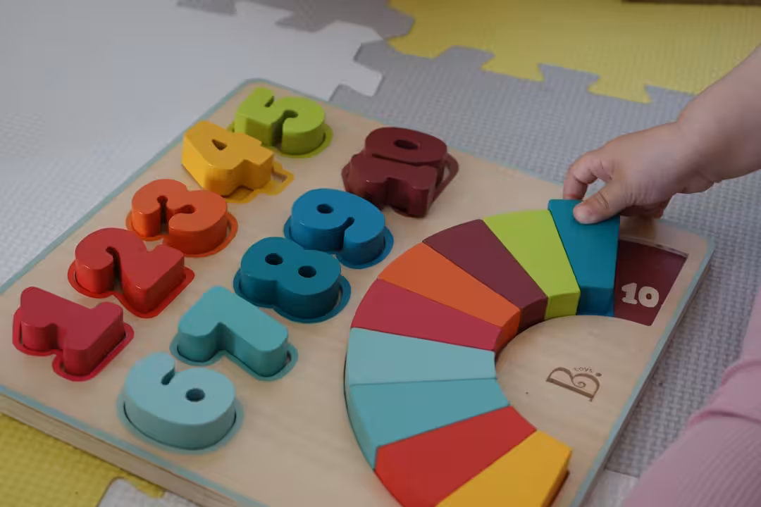 a child is playing with a wooden toy