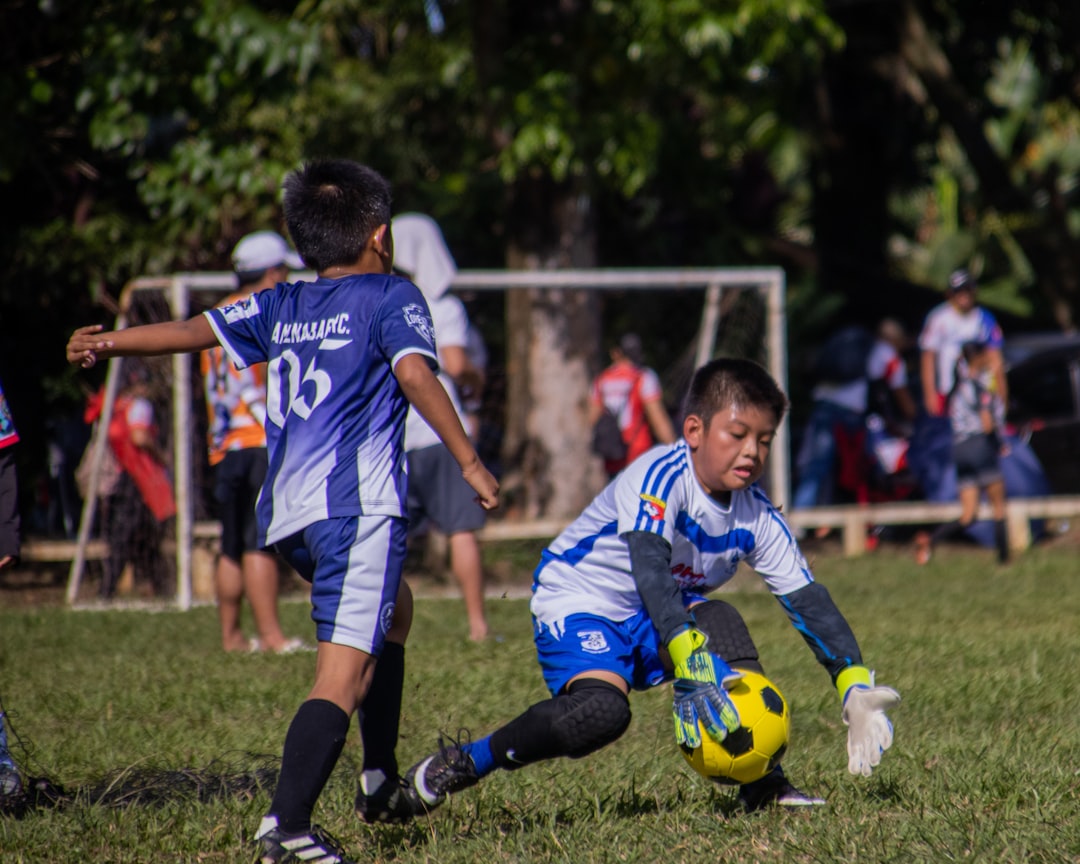 Niños entrenando fútbol en un campo al aire libre