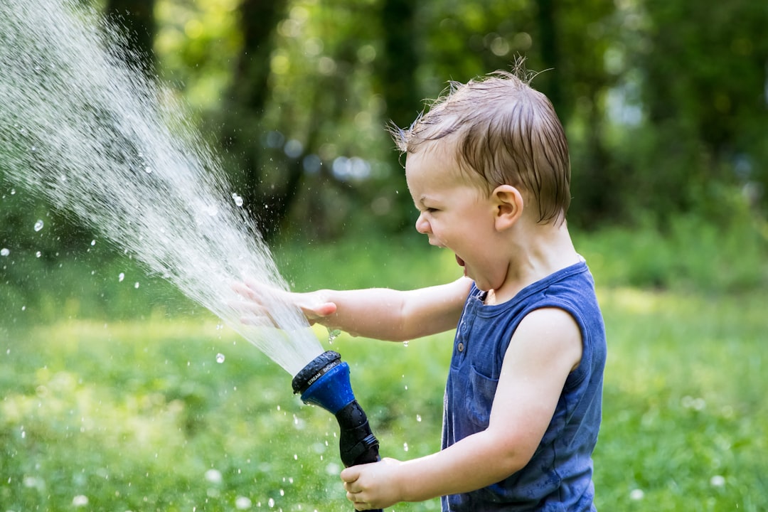 Estimulación temprana - Niña de dos años practicando vida práctica: verter agua sin ayuda