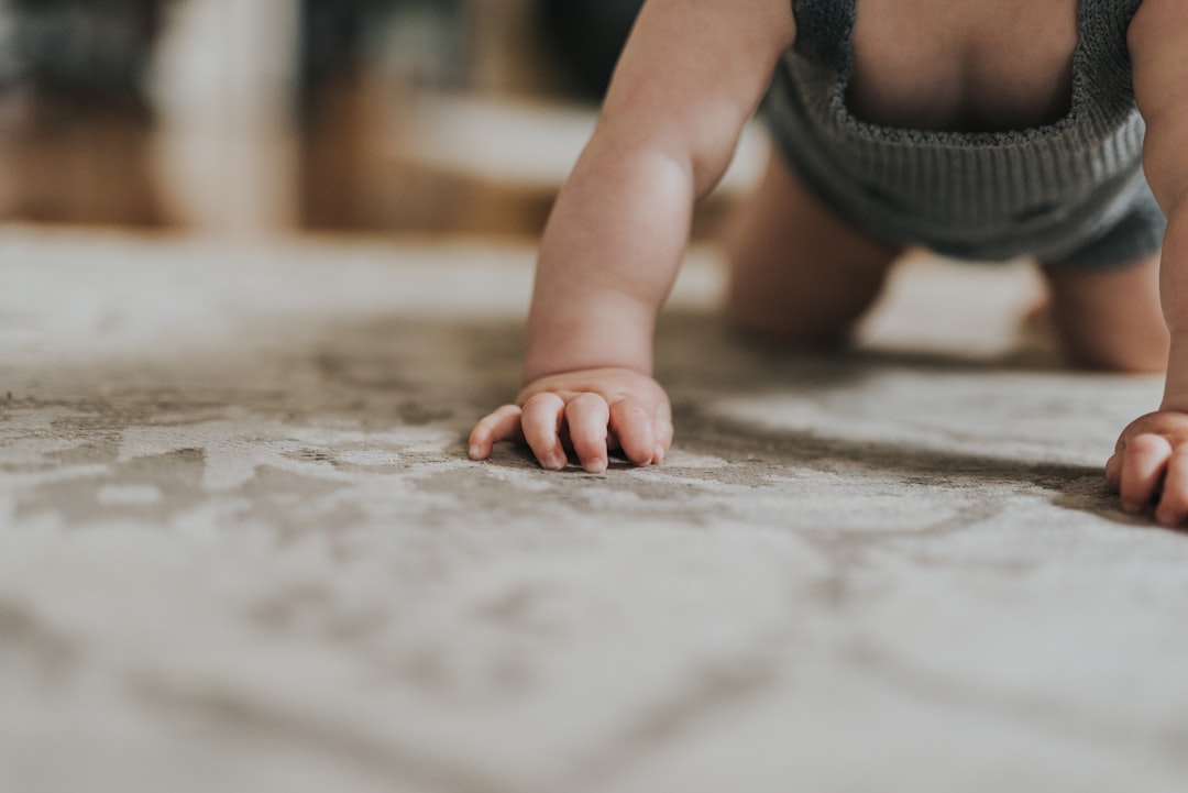 centro infantil Casares - Un bebé descubre texturas y formas en el suelo de su aula.