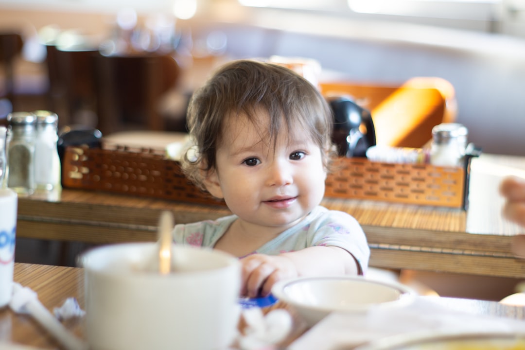 guarderías cerca de Puerto Banús - Niño pequeño aprendiendo a comer solo con vajilla real en el Nido