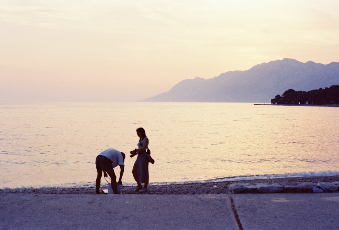 bienestar emocional infantil bilingüe - Familia internacional paseando al atardecer cerca de la costa mediterránea