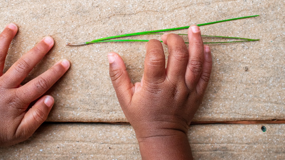 Educación infantil Montessori en Casares - Manos de un niño explorando materiales Montessori auténticos