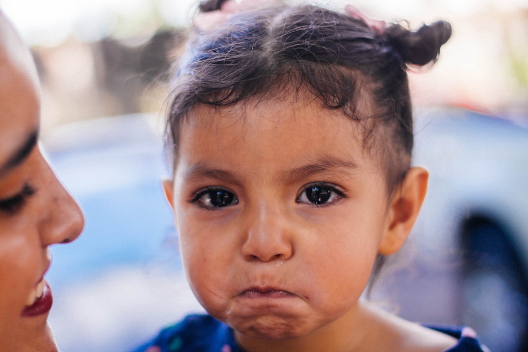 Madre agotada intentando comunicarse con su hijo pequeño