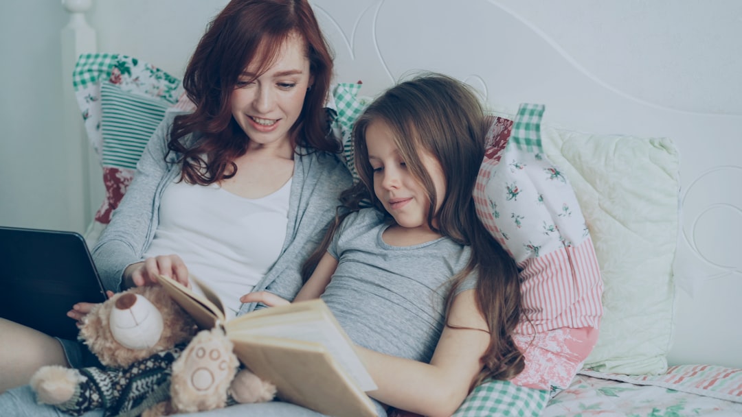 enseñar a dormir solo Montessori - Padre e hijo compartiendo un libro antes del sueño, rutina respetuosa y afectuosa.