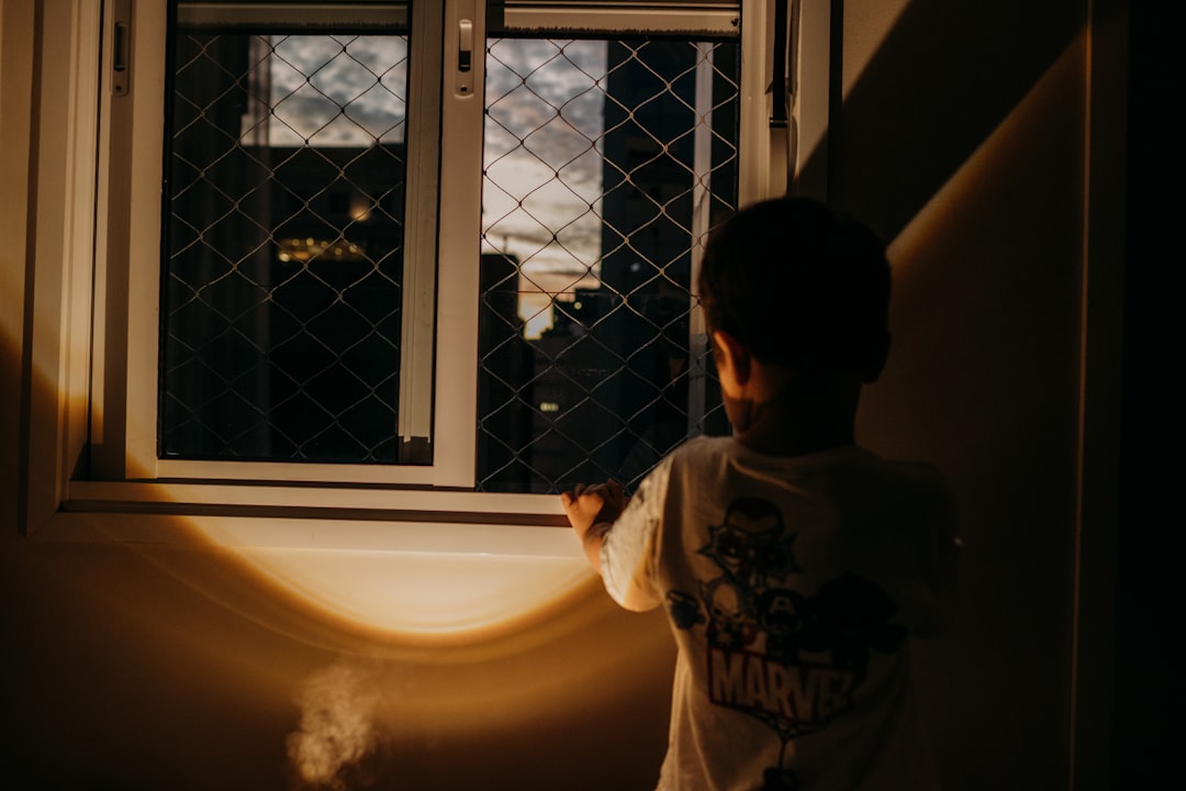 relatos nocturnos para niños - Niño mirando las estrellas por la ventana antes de dormir