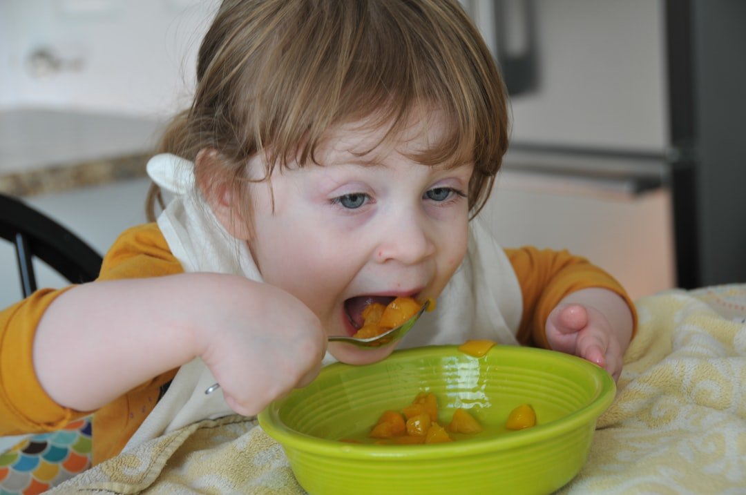 dejar de dar el pecho - Bebé explorando su primera comida sólida con las manos