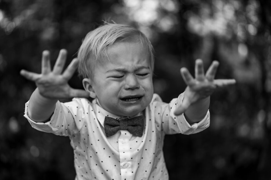 Un padre acompaña con calma la emoción de su hijo durante una rabieta.