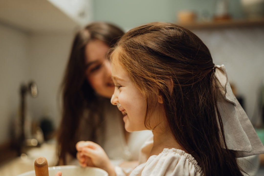 ambiente Montessori en casa - Un pequeño ayuda a preparar la cena en la cocina usando una torre de aprendizaje.