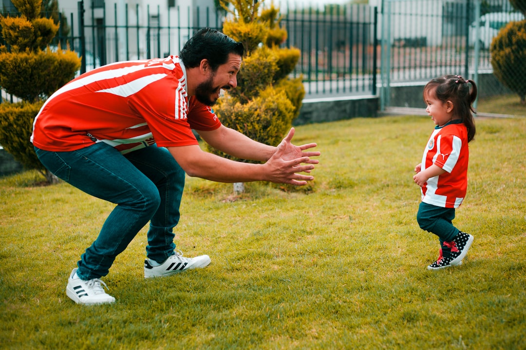 el niño no hace caso - Padre agachándose a la altura de su hijo para hablarle de tú a tú, una técnica Montessori esencial