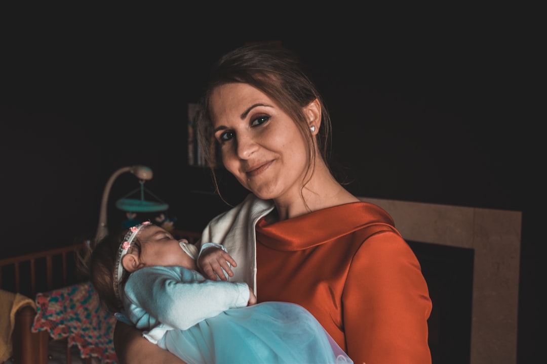 cuánto duerme un bebé según su edad - Madre consolando a su bebé durante un despertar nocturno