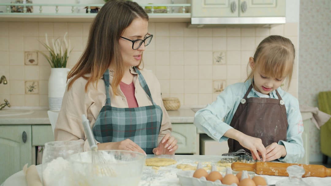 juegos de habilidad manual - Niño pelando una fruta en la cocina con supervisión adulta