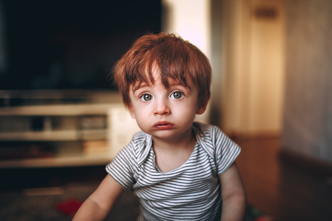 Un niño pequeño expresando una emoción intensa mientras su madre se mantiene cerca con calma.