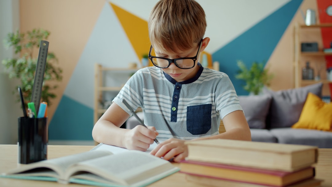 elementos del aula Montessori adaptados al hogar - Niño de primaria trabajando con materiales de investigación en su espacio de estudio