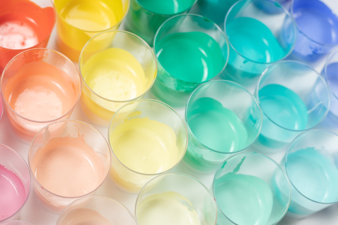 juego sensorial en casa - Preescolar vertiendo agua coloreada en vasos de cristal