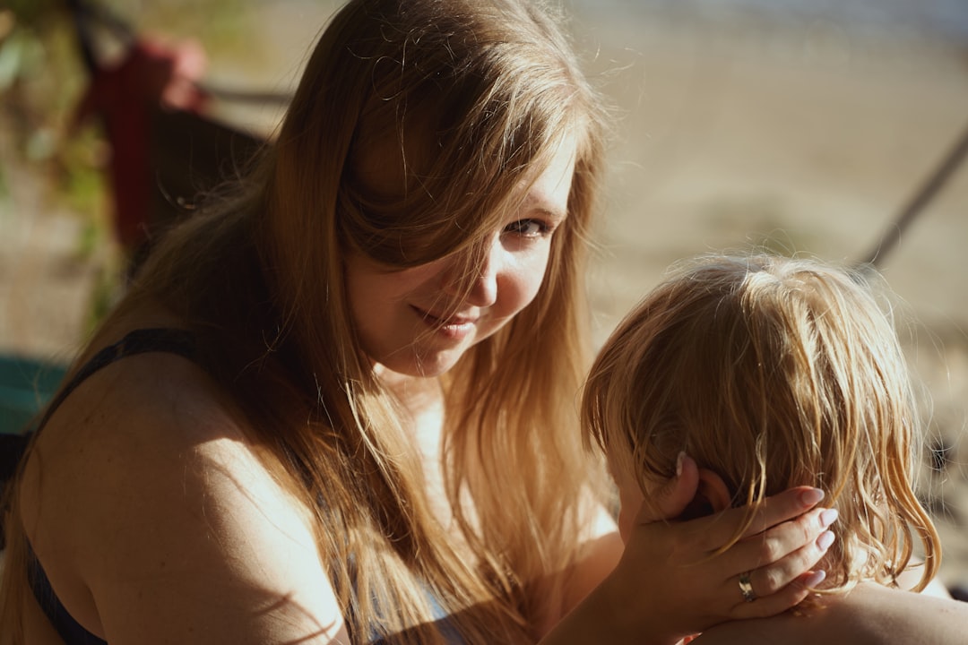 Madre agachándose para hablar con su hijo a la altura de sus ojos