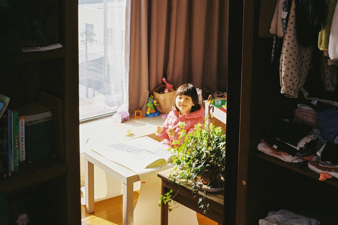 Un niño de 4 años trabaja concentrado con material de vida práctica en un ambiente preparado Montessori en casa.
