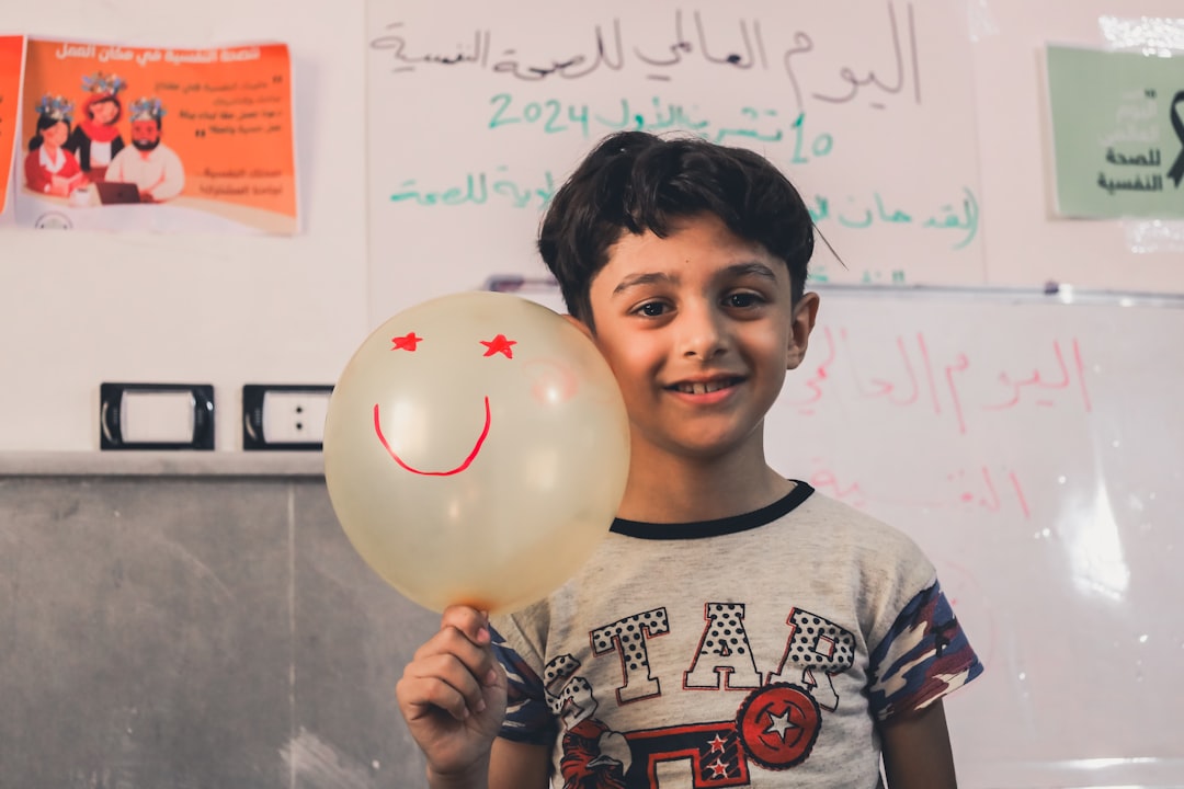 educación bilingüe - Niño sonriente con globos de diálogo en diferentes idiomas: símbolo del bilingüismo.
