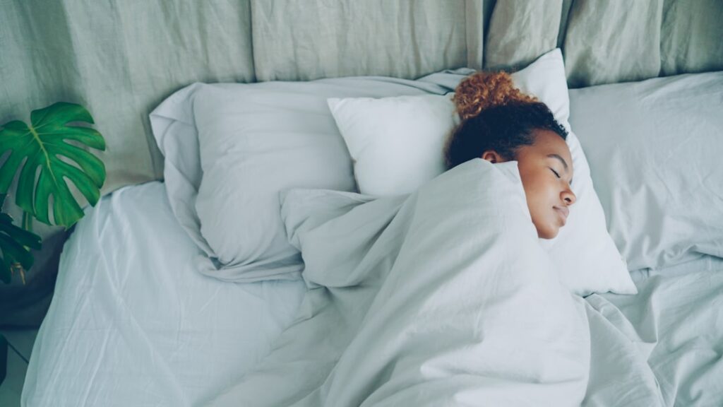 Niño durmiendo plácidamente en su cama, símbolo de un descanso reparador.