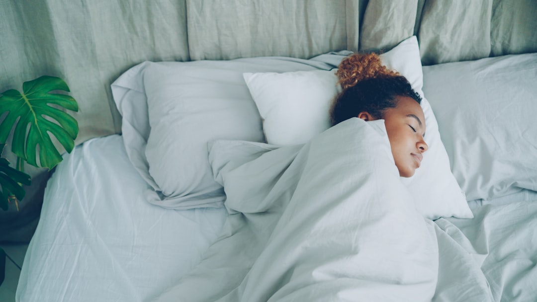 Niño durmiendo plácidamente en su cama, símbolo de un descanso reparador.