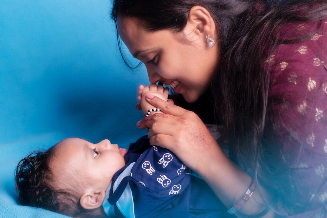 actividades educativas para lactantes - Una madre observa cómo su bebé se concentra en su juego