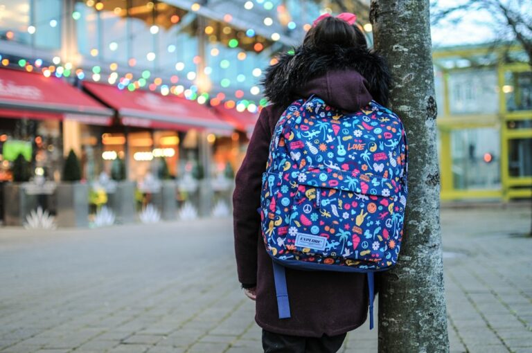 Niño con mochila en su primer dia de colegio, ilusionado ante la entrada.