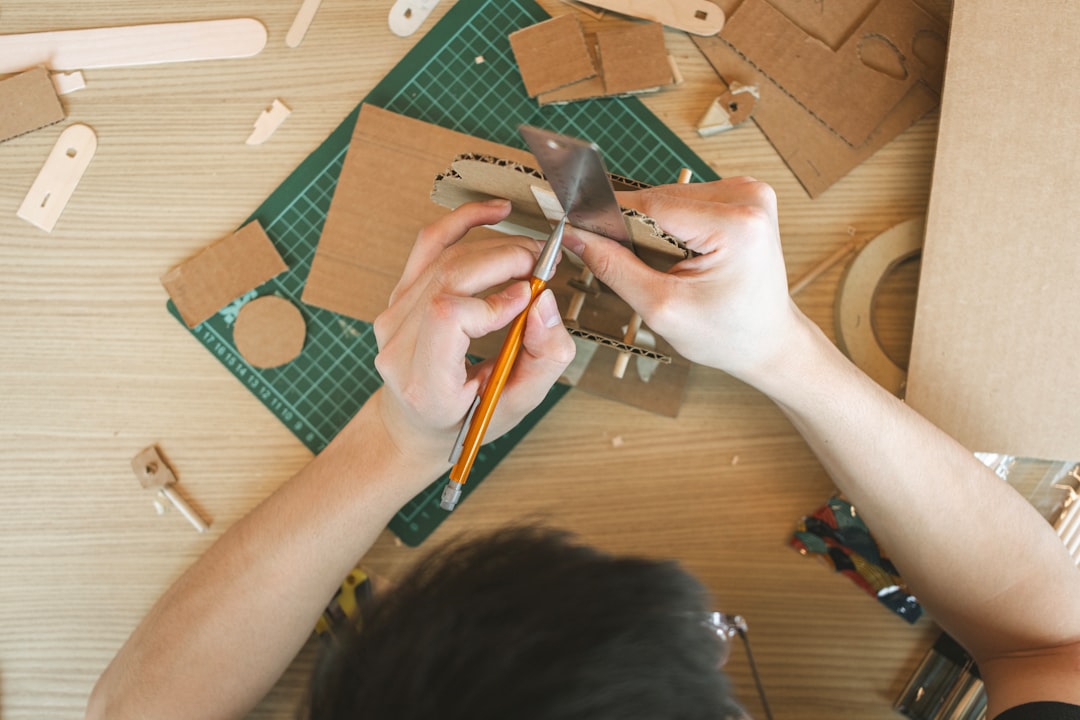 proyectos creativos para preadolescentes - Niño lija una pieza de madera para construir un marco de fotos.