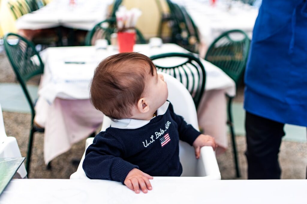 Un bebé comienza a probar alimentos sentado junto a su familia.