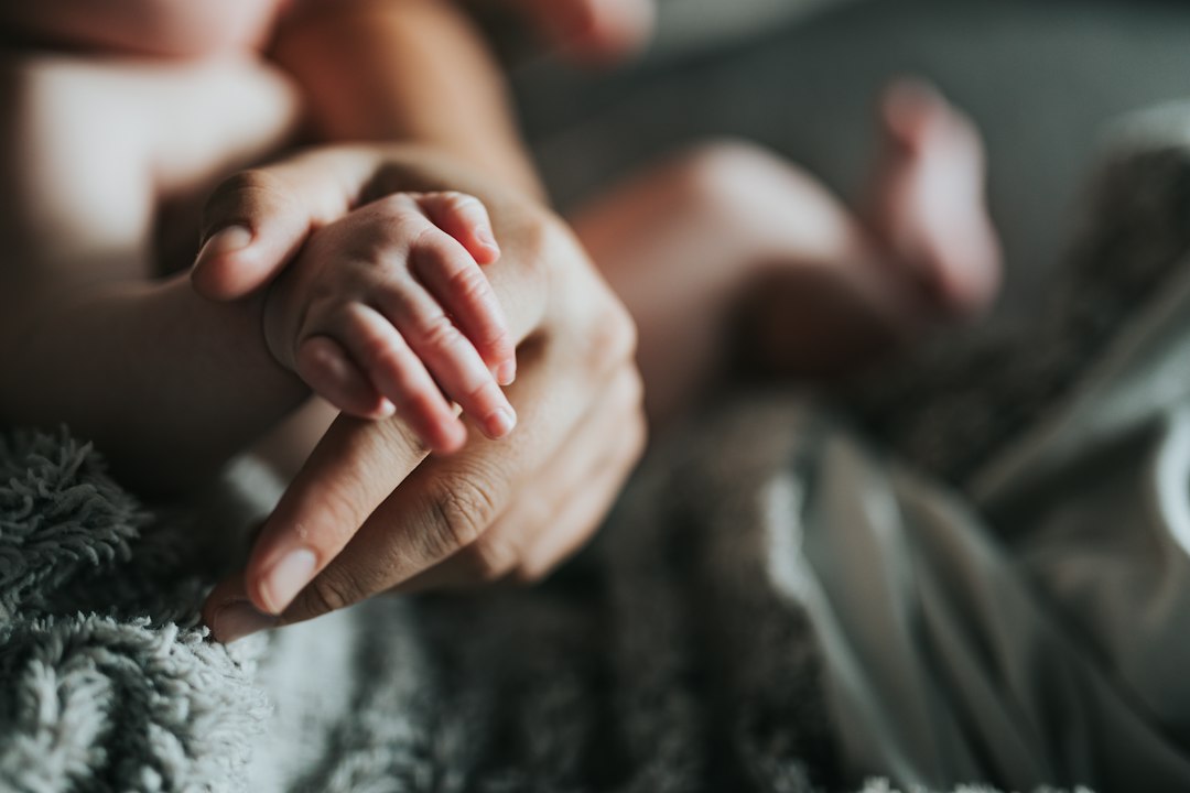 baby massage step by step - person holding babys feet